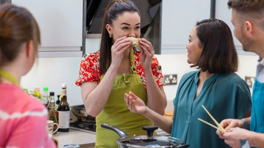 Students enthusiastically learn to cook local dishes from an expert chef in Bali. This photo captures a top Bali cooking class, where participants learn from an expert chef. It highlights a hands-on, engaging culinary experience.