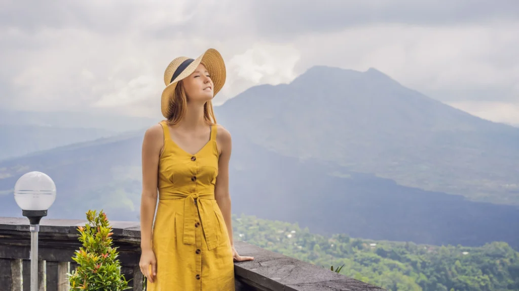 A local guide points towards the summit of Mount Batur, leading a small group of adventurers. This image emphasizes the importance of experienced guides for a safe and informative trekking experience.