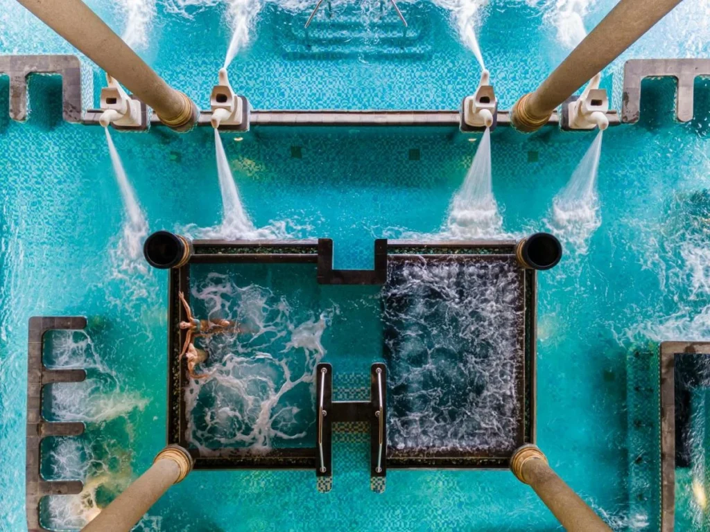 A luxurious outdoor jacuzzi at Ayana Resort and Spa Jimbaran Bay, Bali, offering a serene and upscale experience amidst a beautiful tropical setting.