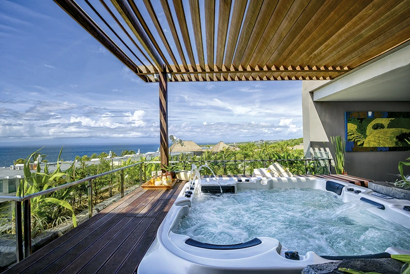 An inviting close-up of a bubbling jacuzzi with a sunny, clear sky, symbolizing the optimal season to experience Bali's luxury and warm climate.