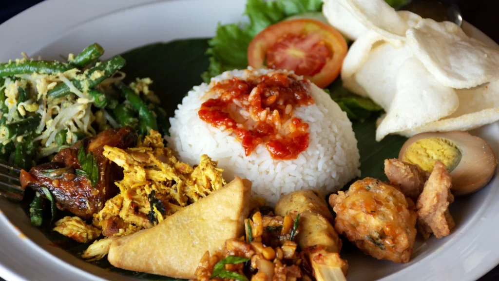 This image shows a colorful and authentic Balinese nasi campur. It features a mix of traditional side dishes, perfect for highlighting genuine Balinese cuisine.