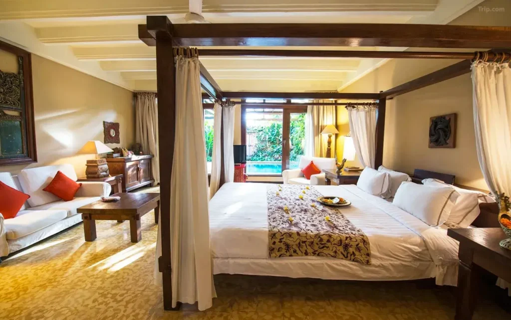 Hotel Tugu Bali displays its unique, art-filled interiors and a serene, traditional Balinese pool area. This distinctive hotel provides a memorable experience, including potential late check-out.