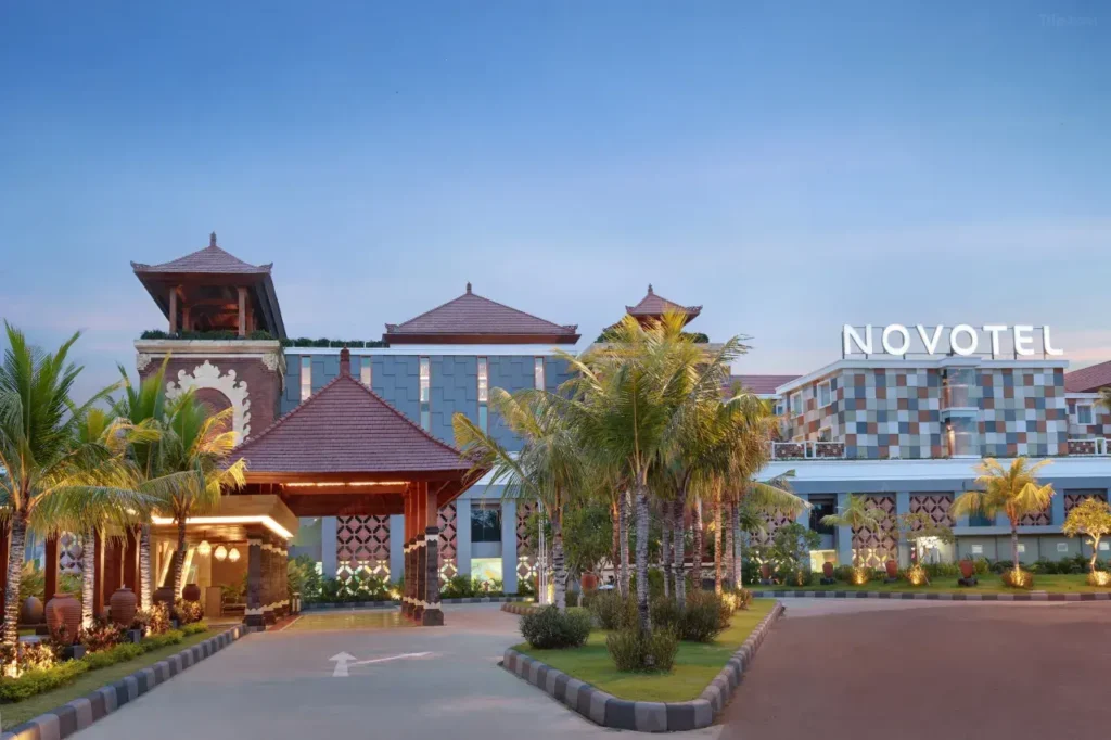 The parking area of Novotel Bali Ngurah Rai Airport, emphasizing its proximity to the airport and free parking for hotel guests. Airport signage might be visible.