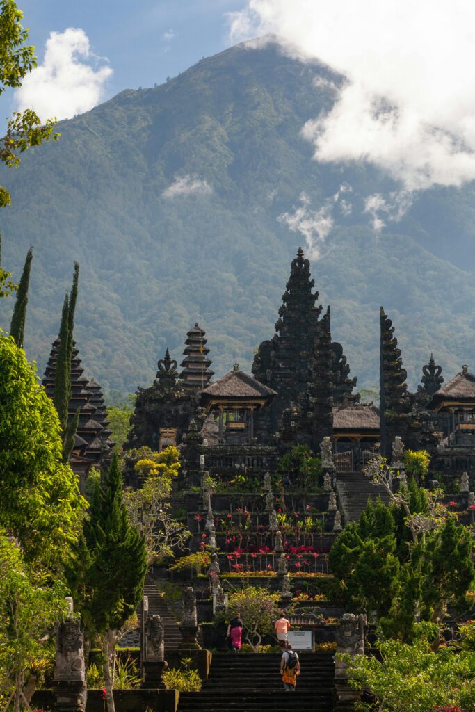 Beautiful Balinese Besakih temple with Mount Agung backdrop, showcasing intricate architecture and lush greenery.