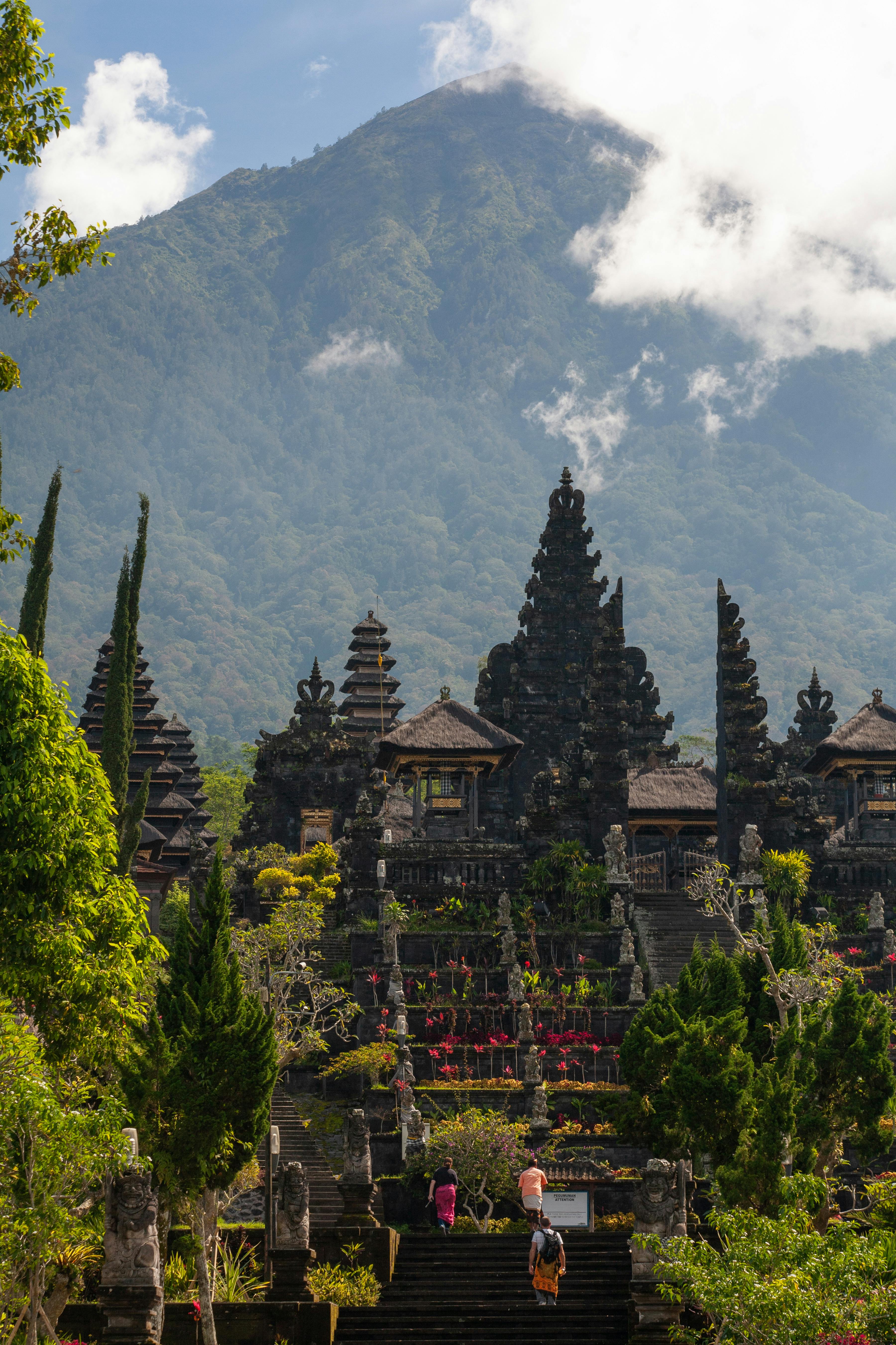- Bali Adventours Beautiful Balinese Besakih temple with Mount Agung backdrop, showcasing intricate architecture and lush greenery.