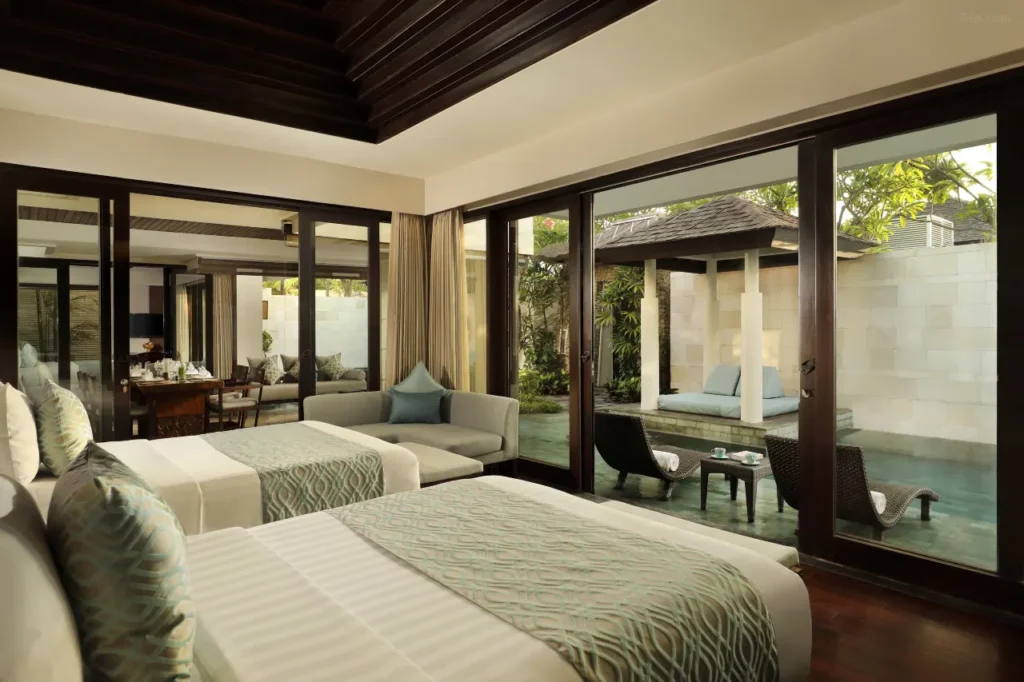 The Seminyak Beach Resort & Spa's stunning infinity pool overlooks the ocean at sunset. This image highlights a luxurious retreat offering late check-out options for families and couples in Seminyak.