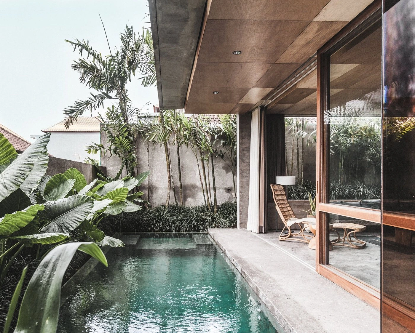 A stylish view of The Slow Canggu, showcasing its unique architecture, minimalist design, or lush surroundings, emphasizing its reputation as a top smoker-friendly hotel in Bali