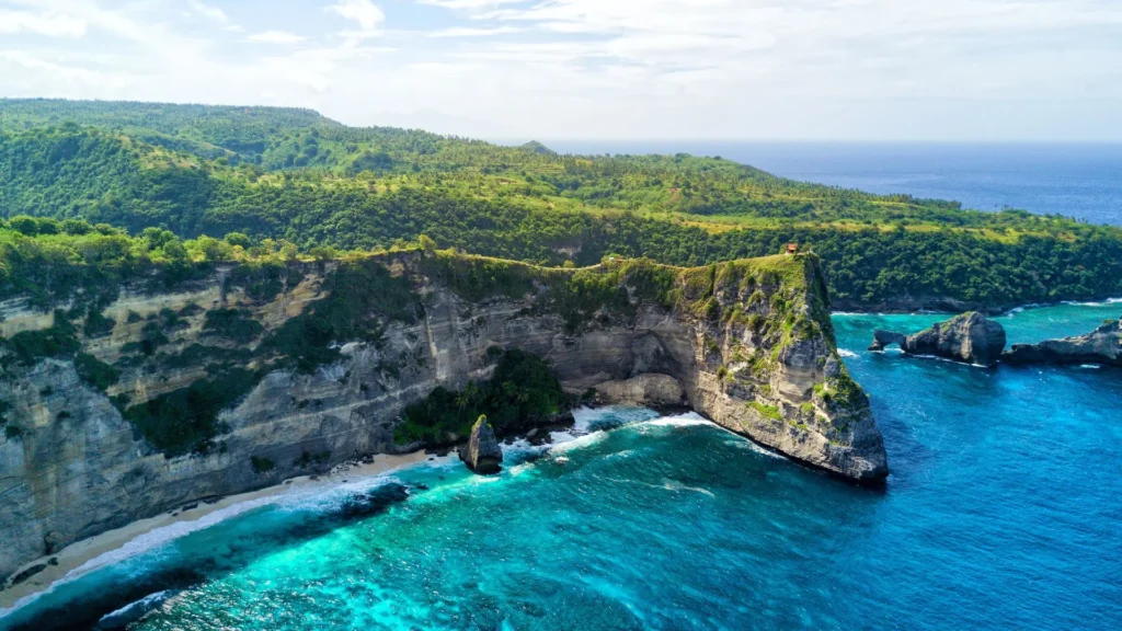 Clear, turquoise waters of Crystal Bay with snorkelers enjoying the reef in Nusa Penida.