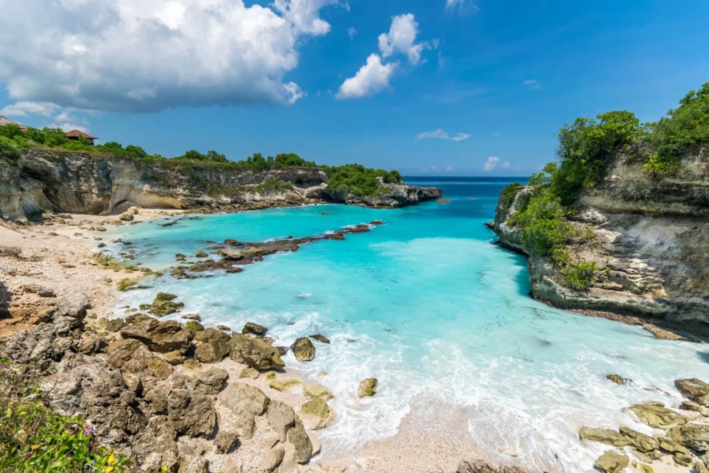 Dramatic cliffside view of Kelingking Beach on Nusa Penida, showcasing its iconic T-Rex shaped cliff and turquoise waters.