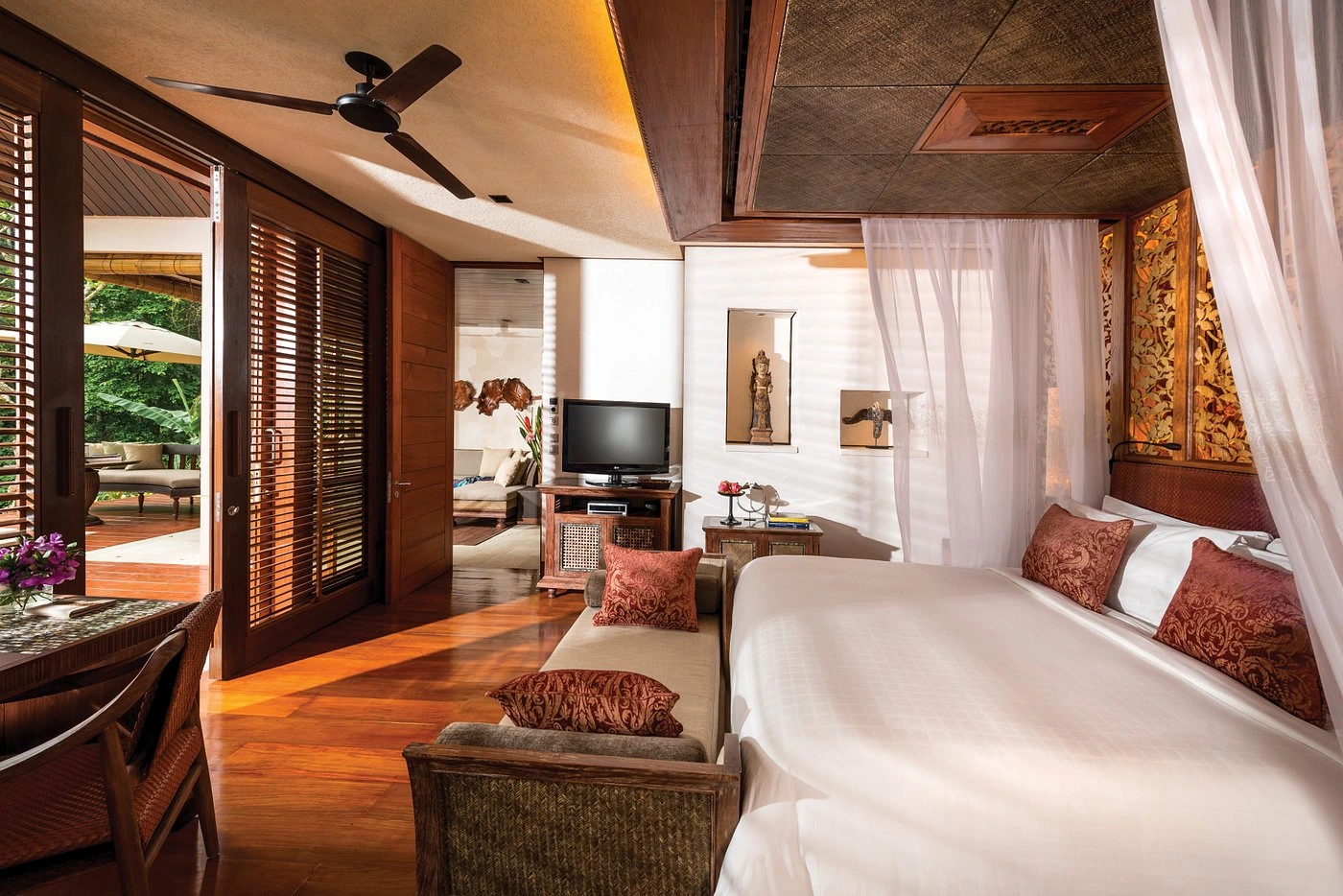 An aerial view capturing the serene and lush landscape of Ubud, Bali, perfect for a honeymoon. The image features expansive, verdant rice terraces, gently rolling hills, and glimpses of tranquil rivers winding through the scenery, highlighting its appeal for nature-loving couples.