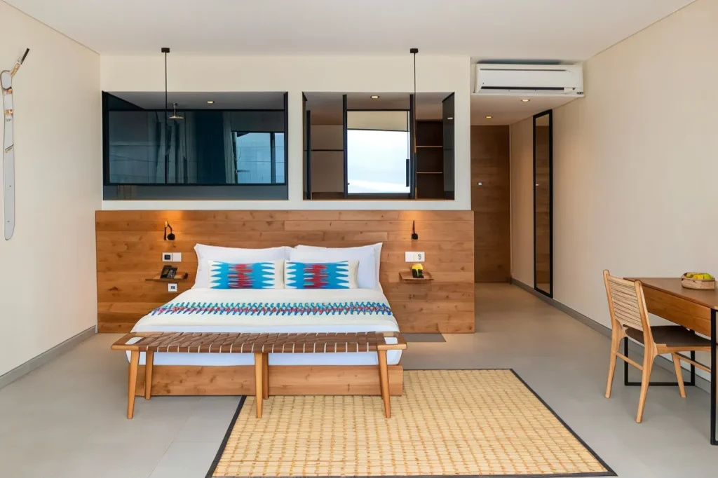 A hotel room with a complete mini kitchen and a simple, minimalist interior.