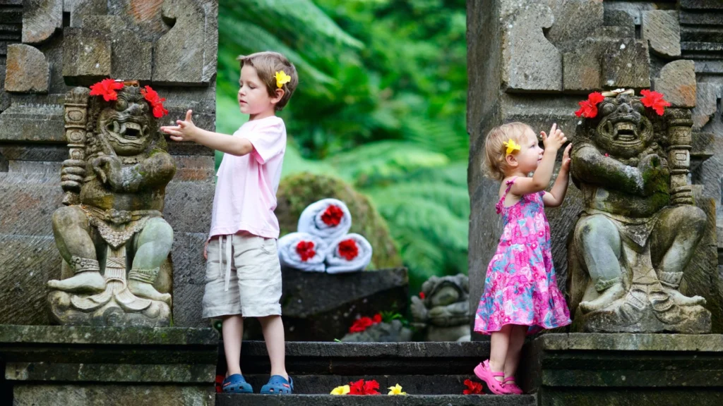 Small children are enjoying their vacation in Bali during the rainy season. The image shows them engaged in activities like playing in puddles, splashing water, or doing indoor activities such as painting or playing games, with a rainy backdrop.