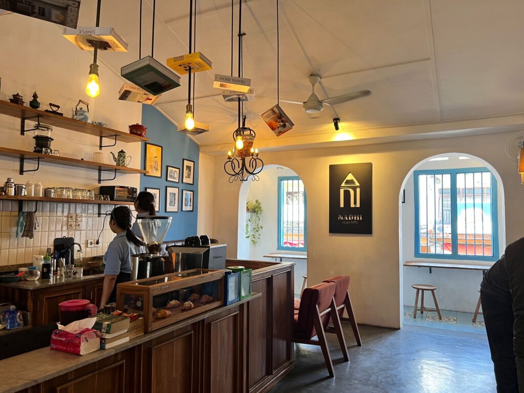 A cozy vintage café with dim yellow lighting, wooden tables, and walls decorated with old photographs, some in black and white, creating a nostalgic atmosphere.