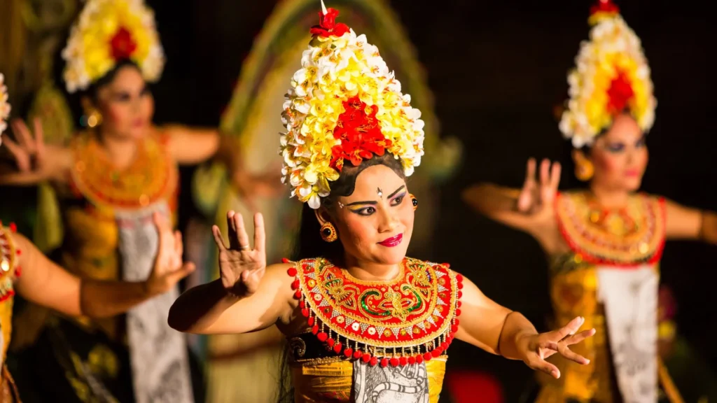 Traditional Balinese Kecak dance performance with dancers in vibrant costumes and firelight during a cultural festival in Bali.