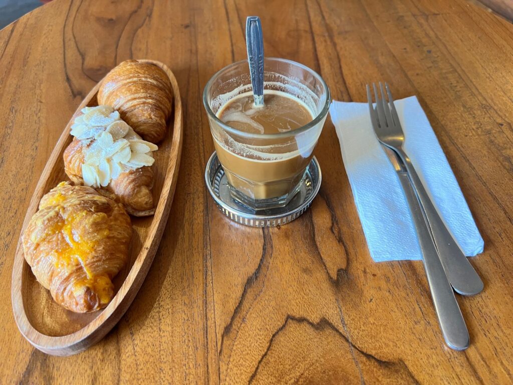 A glass of dark coffee with sweet condensed milk at the bottom, stirred into a strong and sweet brew, served simply without latte art — classic, old-style coffee.