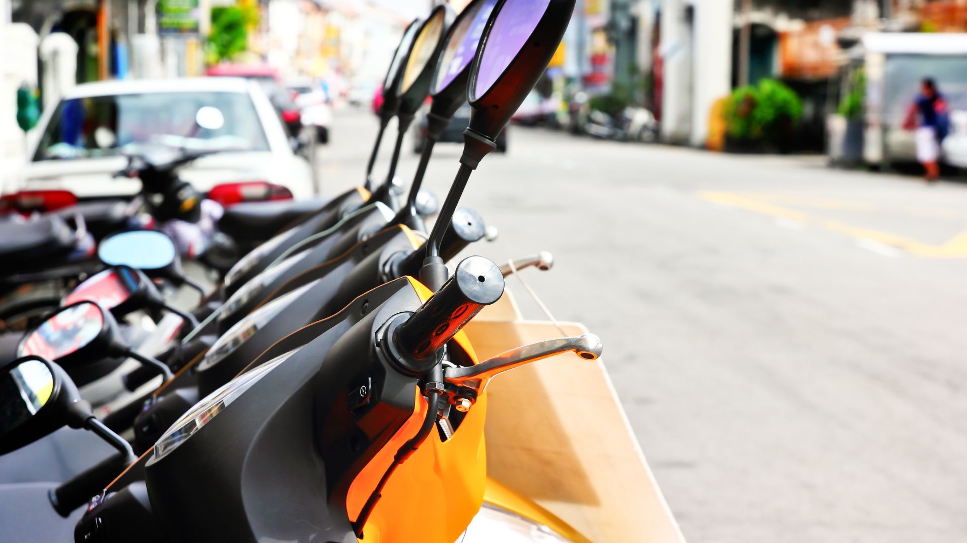 A row of motorbikes available for rent in Bali. The bikes are lined up and ready for tourists to use.