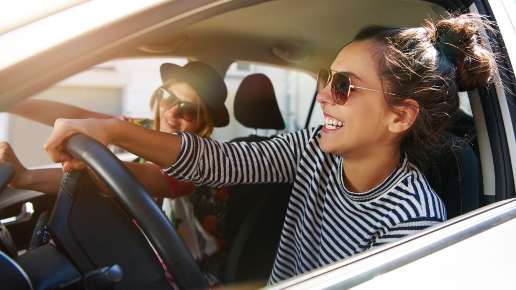 A female tourist in Bali who successfully rented a car for her trip. She looks happy and ready to explore the island.