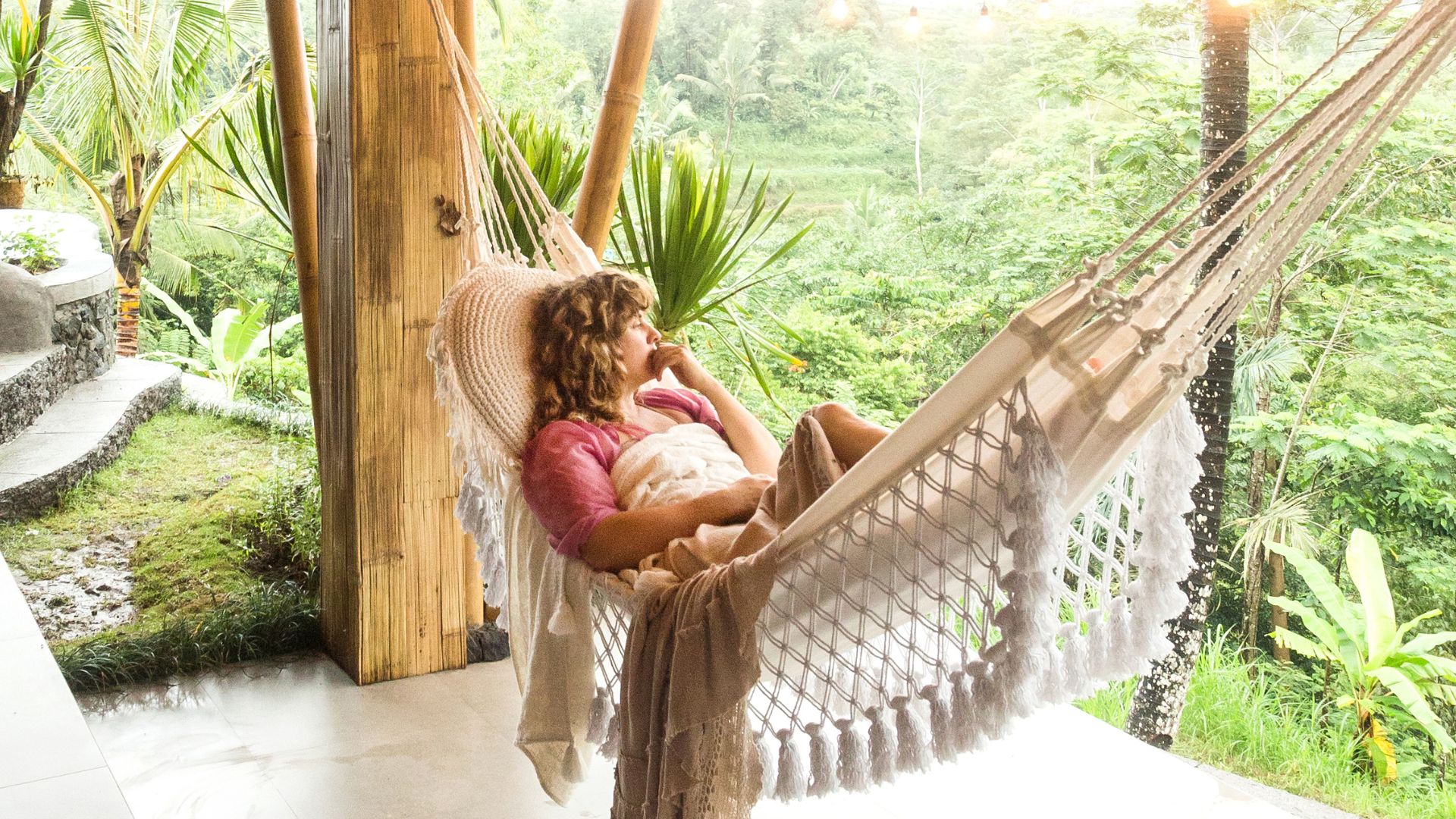 A woman enjoying peace and quiet in Bali. She looks calm and relaxed in a tranquil setting.